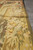 Side view along the olive selvage showing fruit garland border and flat tapestry surface