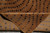 Folded back corner reveals dense hand-knotted construction and brown wool pile with silk dots