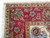 Corner detail of berry red border, gold guard stripes and clean ivory fringe