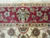 Border close up showing green and ivory palmette motif on deep berry red ground