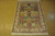Gold, rust and teal garden panels fill this hand-knotted silk rug on a cork showroom floor
