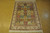 4' x 6' silk garden Bakhtiar rug angled on cork floor showing ivory floral border