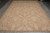 Full view of the tan flatweave area rug laid flat on grey tile flooring