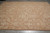 Lengthwise angle showing the all-over lattice of ivory palmettes across a soft coffee ground