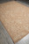 9x13 French Aubusson style rug photographed from the corner on a grey plank floor