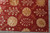 Corner section of the Tibetan modern rug showing selvage, sunflower discs and vine scrolls