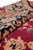Close-up of soft wool pile depth along the black border with salmon beige floral drawing