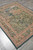 6' x 7' Oriental tapestry rug viewed from the corner on grey flooring, greens and blush tones