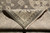 Folded corner revealing cotton foundation and even knotting behind the ivory and gray border design