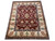 Angled studio photo of hand-knotted wool Agra rug, wine red field and cream shrub border