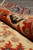 Rolled edge revealing dense wool pile depth, rust border and navy serrated leaf motif