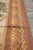 Border close-up showing rust guard stripes, ivory rosette chain and golden acanthus leaf band