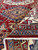 Folded back corner revealing tight knotting, hand-spun wool and multicolored Kazak border stripes