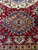 Navy and gold stepped medallion on brick red field with hooked arms and cypress trees