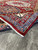 Light blue outer vine border and red selvage on this geometric tribal wool area rug