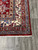 Corner detail of ivory Greek key border, red star guard stripes and ivory cotton fringe