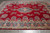 Angled floor shot highlighting the navy border, salmon guard stripes and crimson wool field