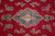 Detail of the blue and ivory center medallion ringed by detached floral sprays on red