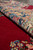 Rolled edge showing thick wool pile, dense cotton foundation and the deep red open ground