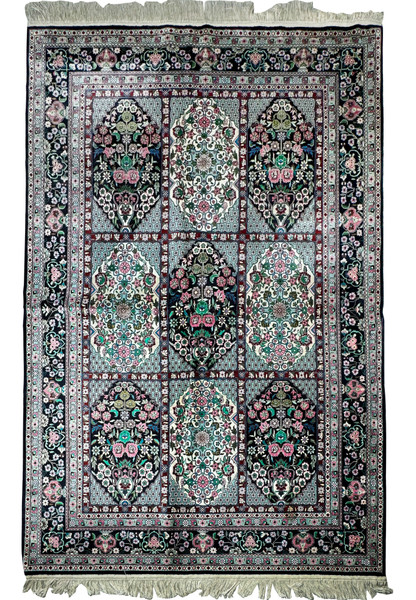 Close-up of the intricate floral and geometric patterns on a Persian Qum silk rug with shimmering silk threads