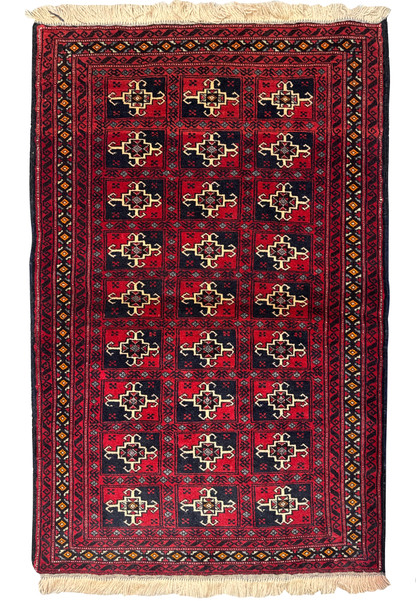 Full view of a 3 x 4'8 Persian Baluch Rug displayed against a white background. The rug showcases traditional motifs in a deep red and black color scheme, with a fringe on the top end.