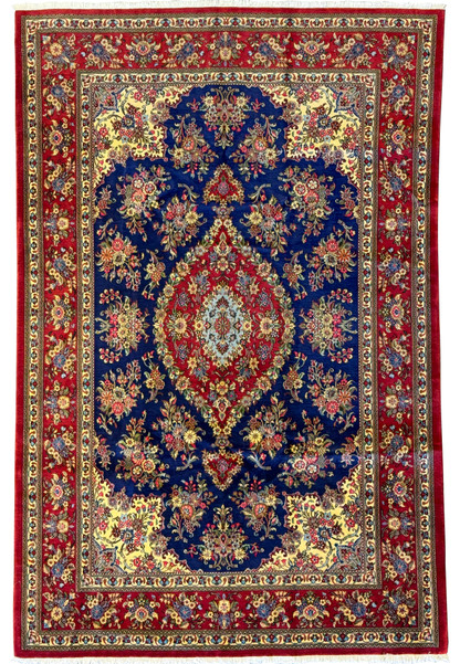 Full view of a 6'5" x 9'9" Persian Qum Kork and Silk Rug showcasing a deep navy blue field with a vibrant central medallion in red and cream, surrounded by intricate floral and vine motifs in red, cream, gold, and green accents