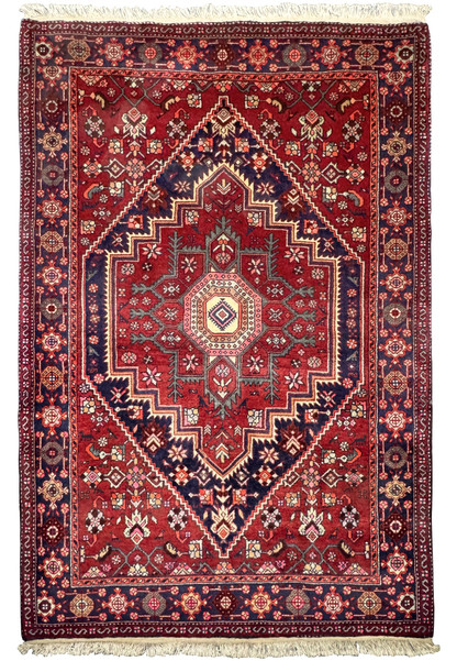 Full view of a 3'4" x 5'1" Persian Gholtogh Rug displayed on a flat surface. The rug's dominant red field is embellished with intricate floral and geometric patterns, framed by detailed navy blue and pastel borders. This hand-knotted wool rug exemplifies the exquisite artistry and durability of traditional Persian rugs.