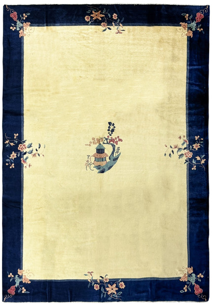 A 10 x 14 vintage Art Deco rug with a navy blue border and a central beige field displaying a stylized vase motif and corner floral designs, in pristine condition
