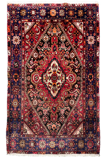 Full view of a 3'4 x 5'5 Persian Gholtogh rug with a deep red field, navy border, bold tribal medallion, and dense hand-knotted wool texture