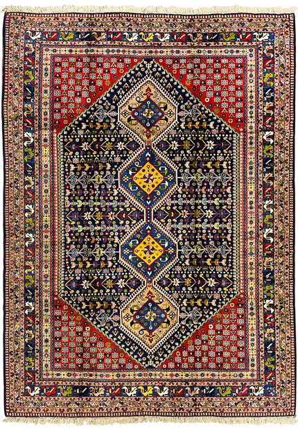 Full view 8'7 x 11'7 Persian Yalameh tribal rug with navy field, brick red corners and bold geometric triple medallion design.