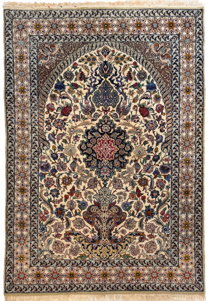 Vintage Persian Isfahan wool and silk rug with floral medallion, mihrab arch, and vase of flowers on an ivory field