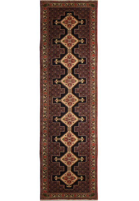 A close-up of a Persian Senneh runner featuring a geometric pattern in shades of blue, red, and ivory.