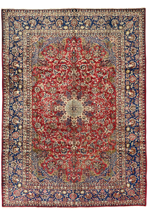 Full view of the 9'9 x 14'5 vintage Najafabad Persian rug featuring a large medallion, ruby red field, and navy floral borders.