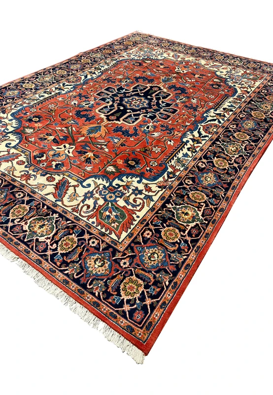 Angled perspective of a fine wool Persian Heriz rug highlighting pile texture, strong geometry, and rich red and navy colors