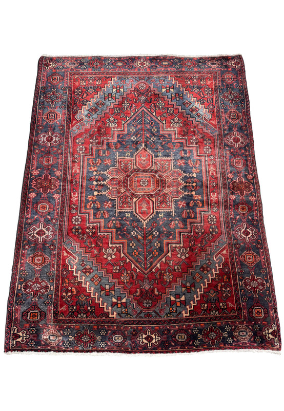 Entire vintage Persian Bijar rug displayed on a flat surface, highlighting its elaborate geometric patterns and the traditional red and blue colors