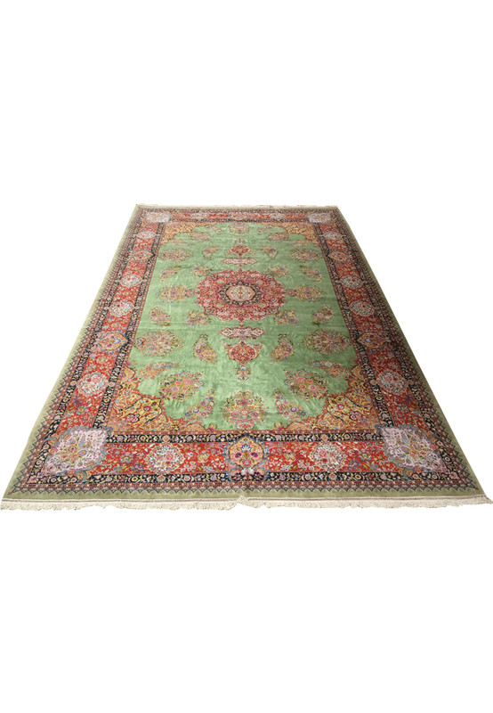 Full view of a 12x18 Persian Tabriz rug, showcasing the elaborate border and central medallion against a tranquil green backdrop