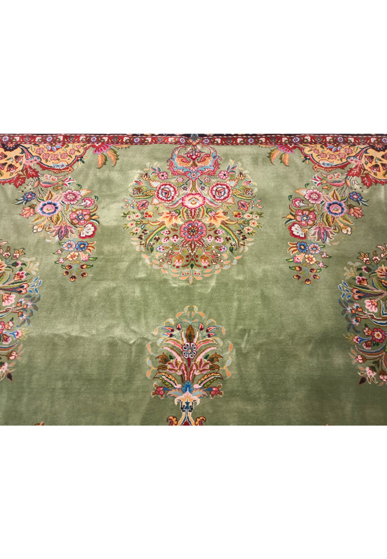 Magnified section of a Persian Tabriz rug, focusing on the lush detailing and rich colors of the border designs.