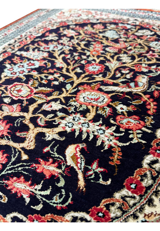 Angled view of the Persian Qum silk rug showing the reflective sheen of the silk threads and depth of the floral motifs