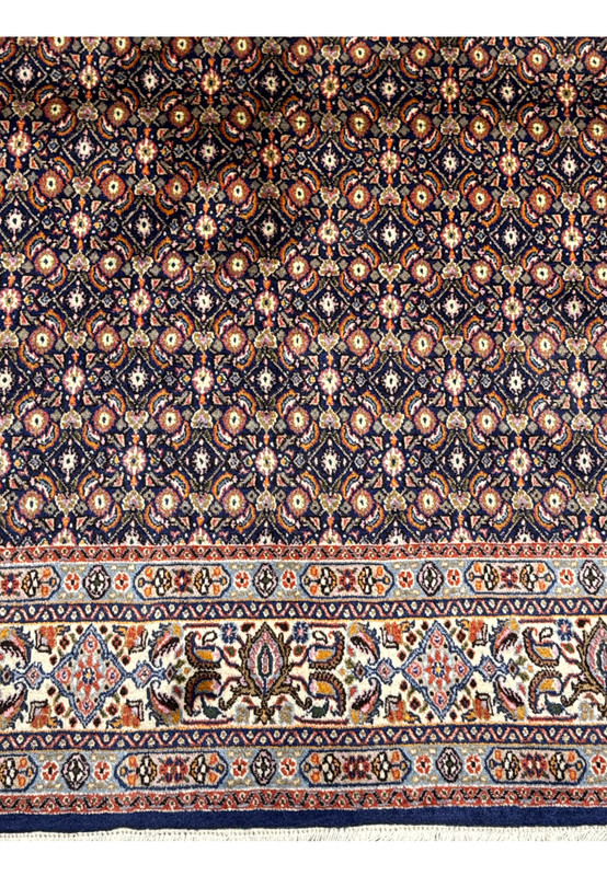 Close-up of the Persian Moud Rug's pattern, highlighting the complex floral motifs and rich colors.