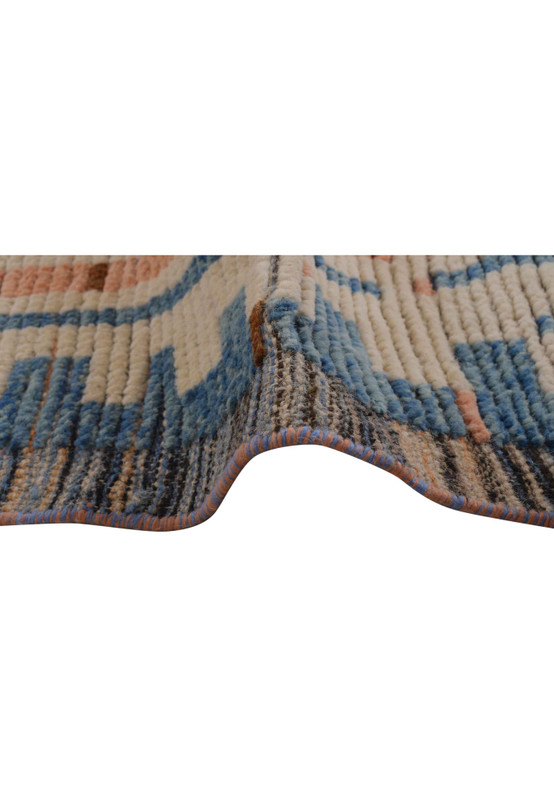 A close-up of the edge of a 12 x 18 modern Moroccan rug, showing the expert craftsmanship and color variation