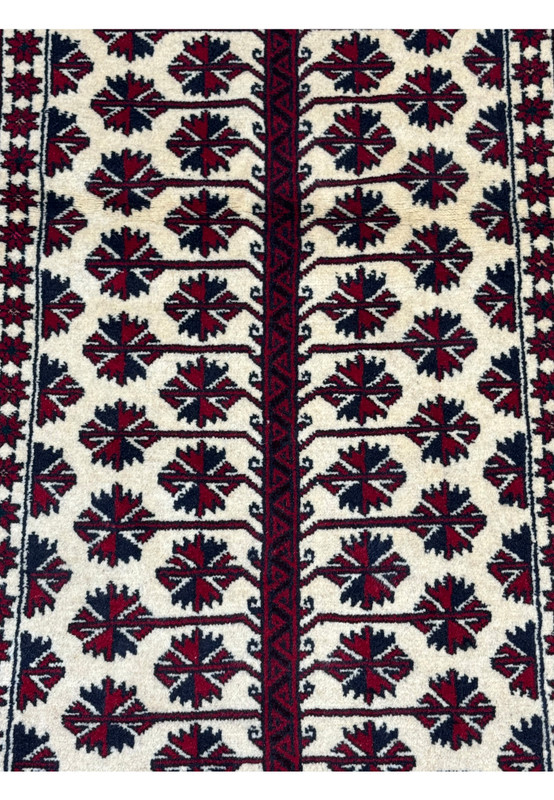 Close-up of the intricate geometric patterns and tribal motifs on the Persian Baluch Prayer Rug