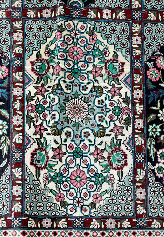 Perspective shot of a Persian Qum silk rug, highlighting the depth of design and vibrant colors