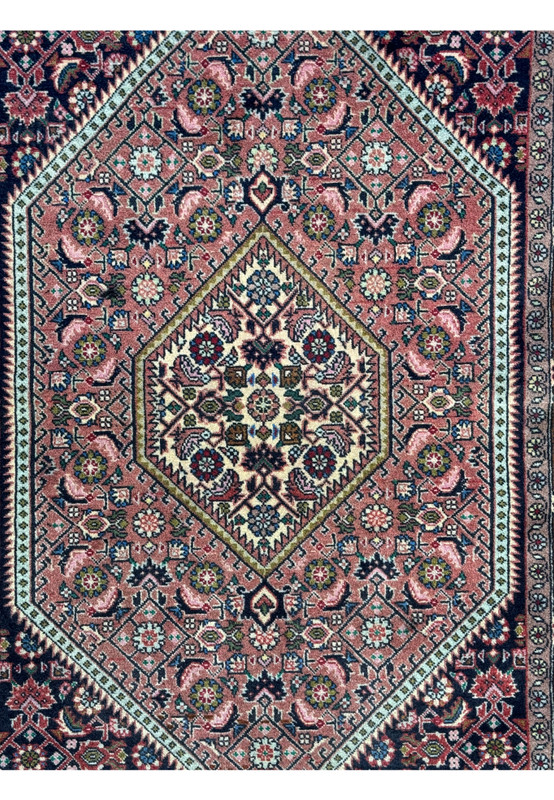 Close-up of the Persian Bijar rug's central medallion with detailed floral motifs and vibrant color contrasts