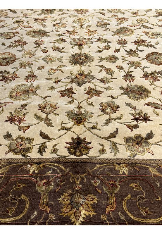 A close-up of the Indian Chobi rug showing the fine detail and color depth in the border and central floral design, with a fringe edge.