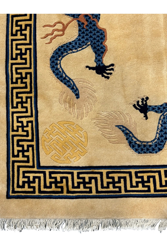 Corner detail of the Chinese Dragon Rug, featuring dragon and Greek key motifs on a beige background