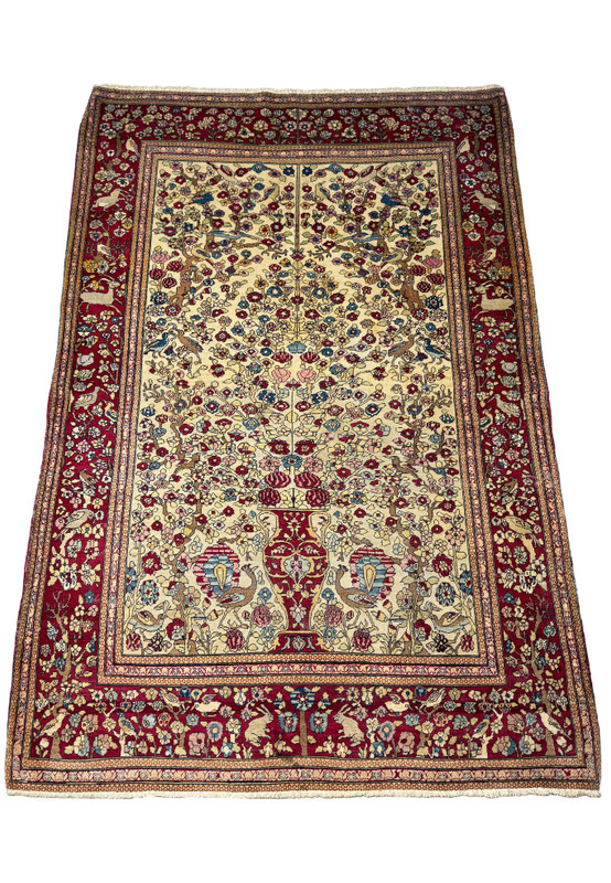 The Antique Persian Farahan rug presented at an angle, emphasizing its lush floral design and intricate border detail