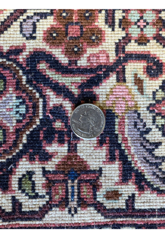 Detailed image of the fine weave of a Persian Bijar rug, with a quarter coin for scale to demonstrate the rug's high knot density and craftsmanship