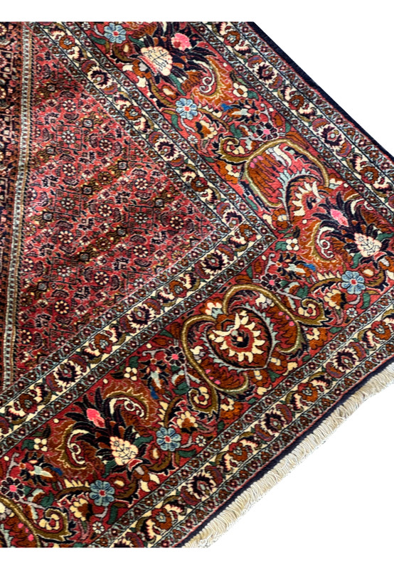 Angled view of the Bijar rug's border, showing the high quality wool that is being weaved with wet wool and therefore called iron rugs