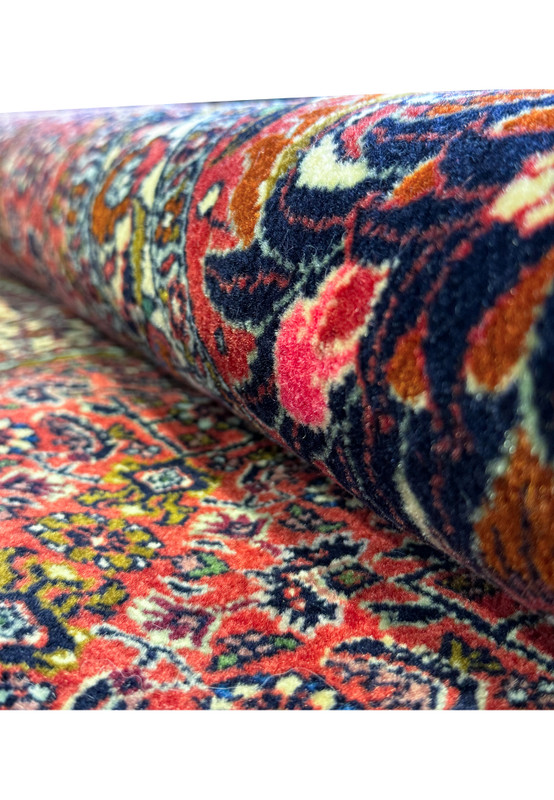 Zoomed-in view of the Bijar rug's ornate border, displaying an array of floral patterns and vivid colors against a dark background