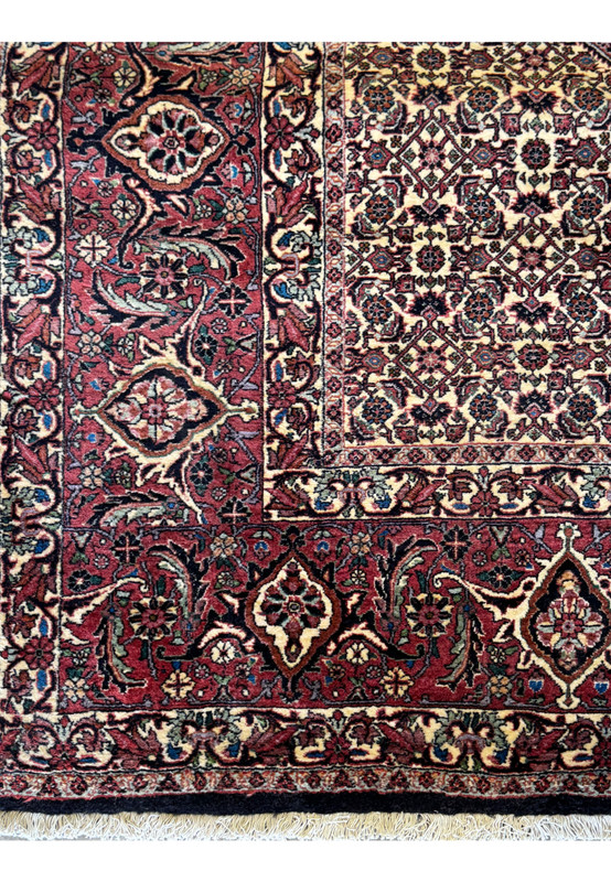 Close-up on the edge of a Persian Bidjar rug, emphasizing the tight weaving and the transition of patterns from the border to the central field